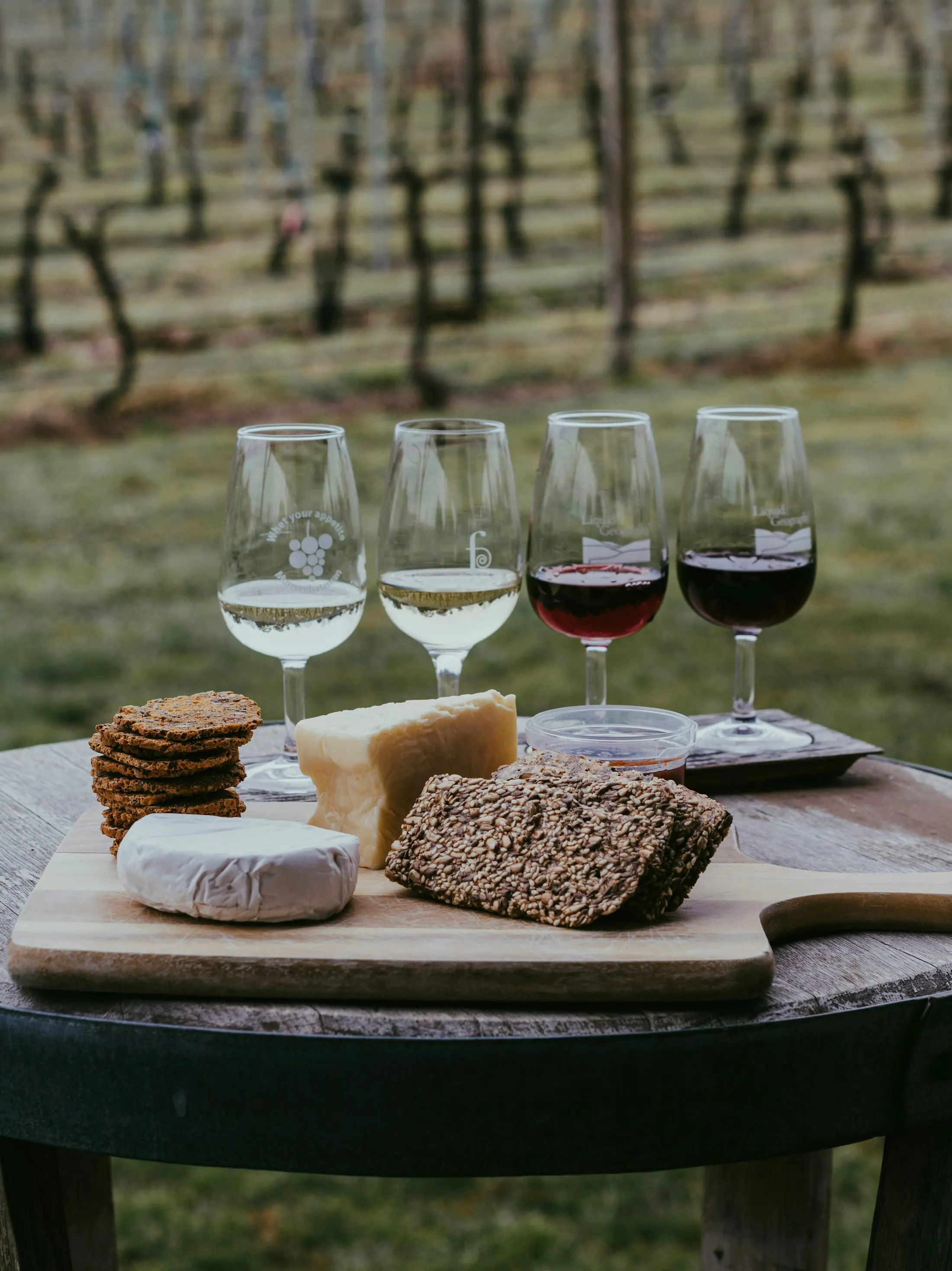 A tasting flight laid out on a table at the edge of the vines